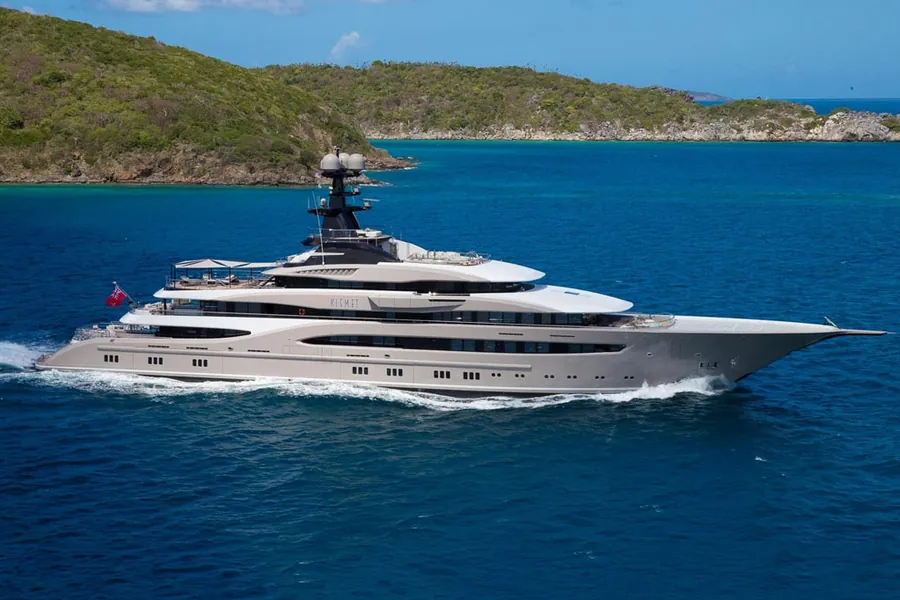 Superyacht cruising past a green island